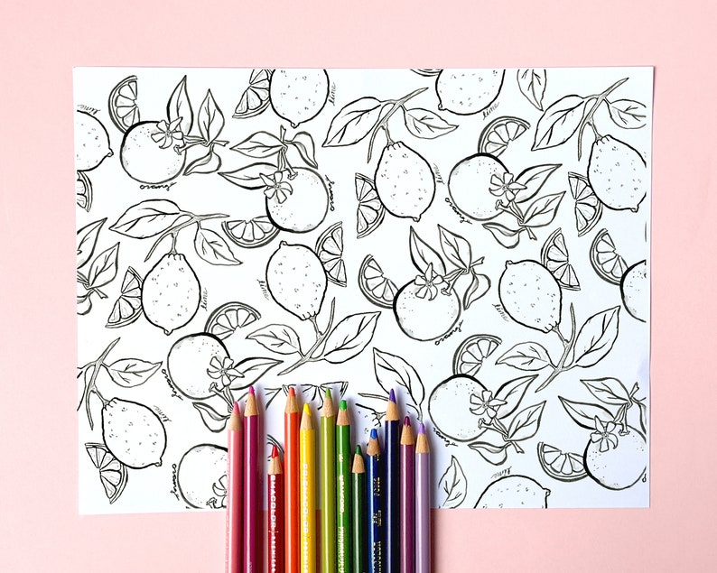 May include: A white sheet with a black and white lemon and orange pattern, with the words "lime" and "orange" written on the fruit. A set of colored pencils in various colors are arranged at the bottom of the sheet.