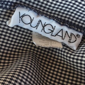 May include: White tag with black text that reads "YOUNGLAND" with care instructions and size information. The tag is on a black and white gingham fabric.