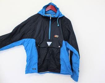 May include: A blue and black windbreaker jacket with a zipper and a hood. The jacket has a pocket on the front and the word "Rukka" printed on the chest.