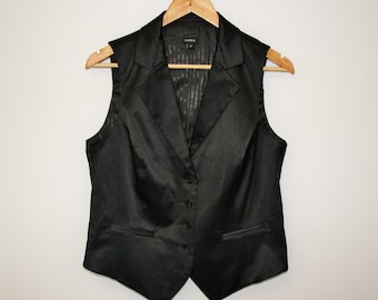 May include: A black satin sleeveless vest with a V-neck and button closure. The vest has a subtle striped pattern and two pockets.