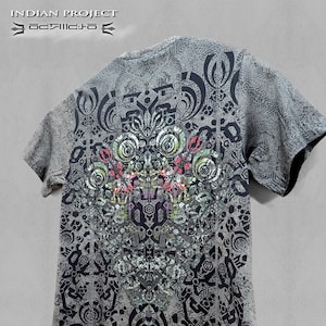 Puede incluir: Camiseta gris con un diseño simétrico detallado en negro, verde, rojo y blanco. La camiseta presenta el texto "INDIAN PROJECT" y "T-SHIRTS COLORS FRAME" en la parte superior e inferior derecha.