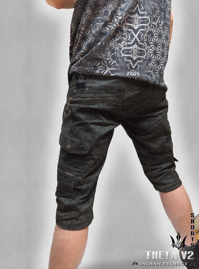 May include: Dark gray cargo shorts featuring a subtle geometric pattern, multiple zippered pockets, and a small black patch with a trident logo on the back waistband. The shorts are paired with a matching gray patterned t-shirt.