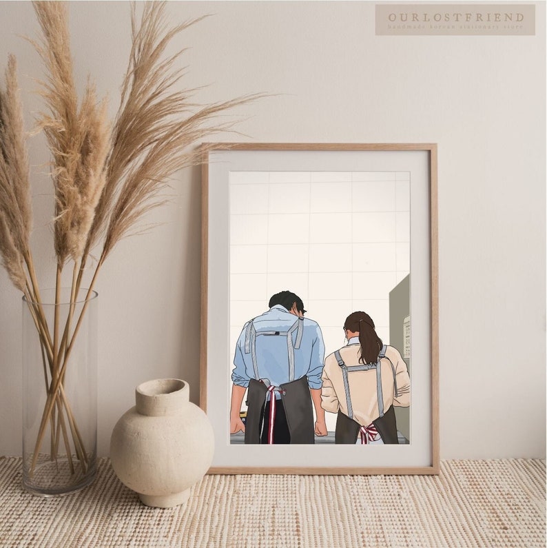 May include: A digital illustration of a couple wearing blue and beige aprons, standing back to back in a kitchen setting. The illustration is in a white frame.
