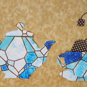 May include: A blue and white teapot and teacup with a stained glass design. The teacup has a brown and white polka dot tea bag hanging from it.