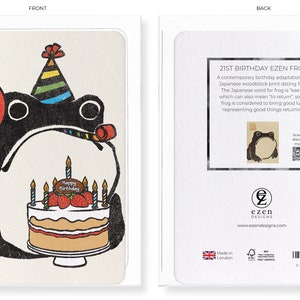 May include: A birthday card featuring a black frog illustration holding a red balloon with the number 21. The frog wears a party hat and holds a party horn. A cake with strawberries and candles is in front of the frog. The back of the card has text.