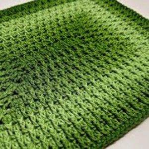 May include: A green crocheted rectangular rug with a gradient pattern. The rug is made with a textured yarn and has a subtle sheen.