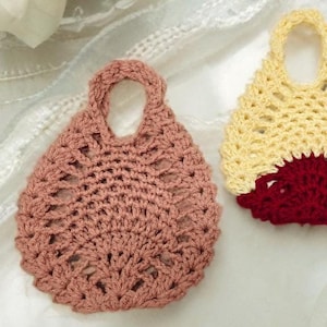 May include: Two crocheted bags, one in a light pink color and the other in a yellow and red color.