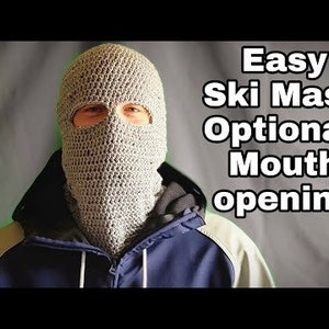 May include: A person wearing a gray crocheted ski mask with eye holes and an optional mouth opening. The text "Easy Ski Mask Optional Mouth opening" is displayed above the person's head.
