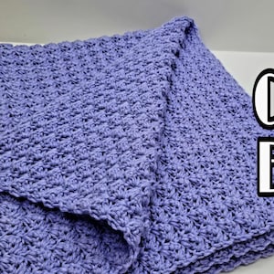 May include: A folded, lavender-colored crochet blanket. The blanket has a textured, star-like stitch pattern. The image also contains the text "Easy Crochet Blanket" in white and black.