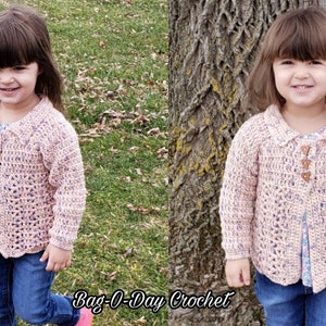 May include: A young child wearing a pink crocheted cardigan with wooden buttons. The cardigan has a scalloped hem and a collar. The child is standing in a grassy area and smiling.