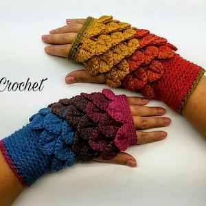 Op de afbeelding: Een paar kleurrijke gehaakte vingerloze handschoenen met een draken schubbenpatroon. De handschoenen zijn gemaakt in tinten blauw, bruin, roze, oranje en geel.
