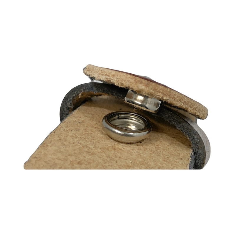 Peut inclure: Gros plan sur une ceinture en cuir marron avec une fermeture &agrave; pression m&eacute;tallique. Le fermoir est ouvert, r&eacute;v&eacute;lant l'anneau m&eacute;tallique &agrave; l'int&eacute;rieur.