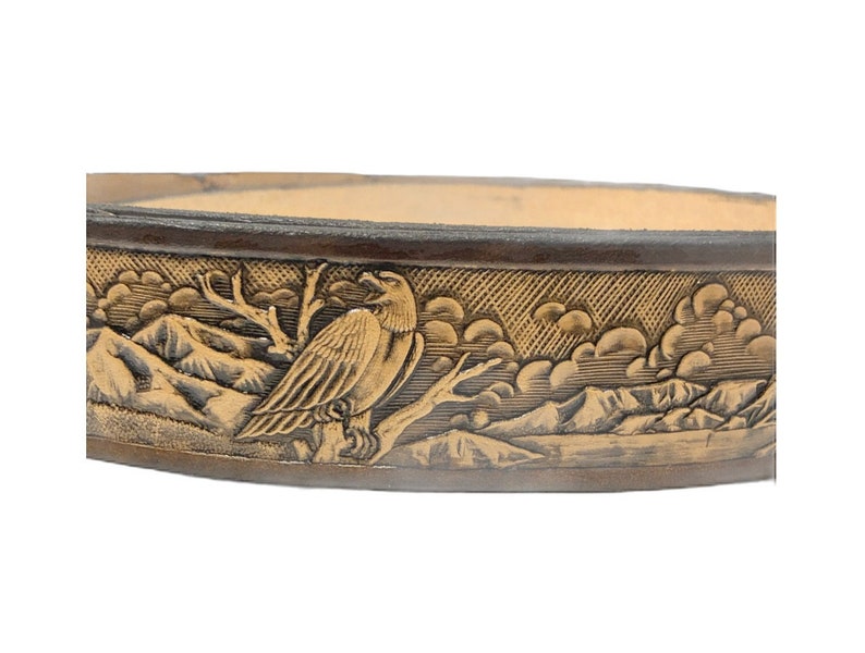 Peut inclure: Une ceinture en cuir marron avec un aigle et une sc&egrave;ne de montagne en relief dor&eacute;.