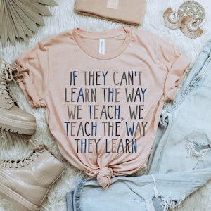 May include: A light pink t-shirt with the text "If they can't learn the way we teach, we teach the way they learn" printed on it.
