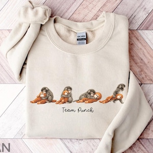 Puede incluir: Una taza de cerámica blanca con un asa negra y el texto "But First, Coffee" en un estilo manuscrito. La taza es para bebidas calientes y tiene un acabado brillante.