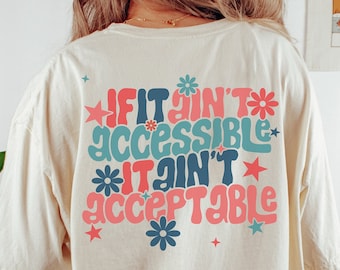 May include: A light beige t-shirt with a retro-style graphic that reads "If it ain't accessible it ain't acceptable". The graphic features colorful flowers and stars.