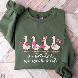 Camiseta do Esquadrão de Apoio ao Câncer de Mama, Moletom Silly Goose, Camisetas Engraçadas de Conscientização sobre o Câncer de Mama, Em Outubro Usamos um Suéter com Laço Rosa