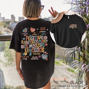 Pode incluir: Camiseta preta com um gr&aacute;fico colorido que diz "Positive Reinforcement Is My Love Language" e inclui frases como "You Are Worth It", "You Matter", "You Are Important", "You Belong Here", "You Are Loved", "You Are Respected", e "You Have A Voice You Are Valued".
