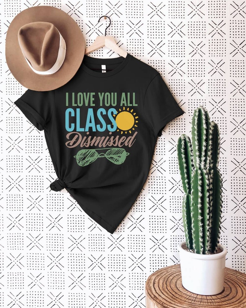 May include: Black t-shirt with the text "I love you all Class Dismissed" in white and blue lettering. A yellow sun and green sunglasses are also on the shirt.