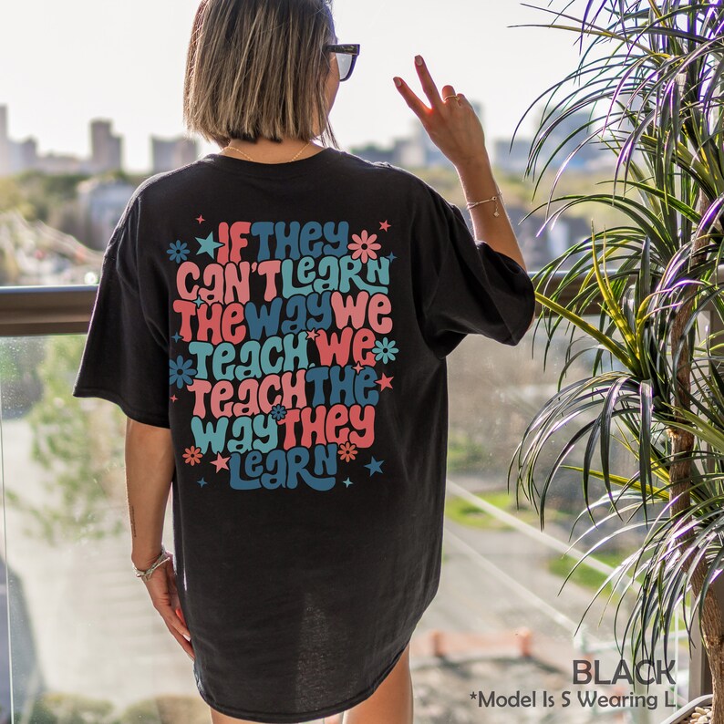 May include: Black t-shirt with a colorful graphic print that reads "If they can't learn the way we teach we teach the way they learn".