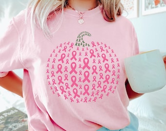 Op de afbeelding: Lichtroze sweatshirt met een pompoenontwerp gemaakt van roze linten en een groene stengel. De linten zijn in een cirkelvorm gerangschikt. De sweatshirt heeft een lichtroze kleur.