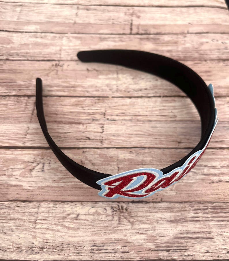 May include: A black headband with a red glitter "Radi" patch.
