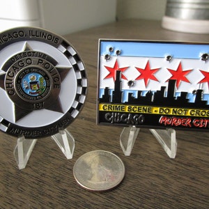 Può includere: Due monete da sfida in metallo, una con una stella del Dipartimento di Polizia di Chicago e l'altra con lo skyline di Chicago e il testo "CRIME SCENE - DO NOT CROSS CHICAGO MURDER CITY".