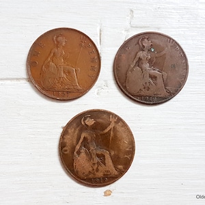 May include: Three copper British pennies, one from 1919, one from 1918, and one from 1927. Each coin features a profile of a woman with a crown on her head.