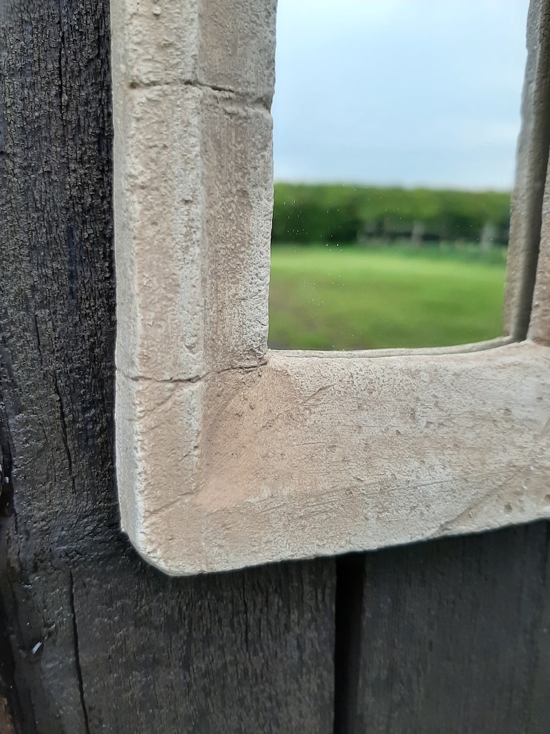 May include: Close-up of a white painted wooden frame with a textured surface. The frame is attached to a dark wood surface.