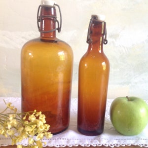 2 French antique hand blown glass bottles with ceramic tops. 2 large amber glass bottles with ceramic stoppers. 2 apothecary bottles.