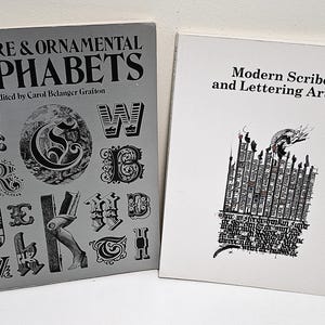May include: Two books are displayed. The book on the left is titled "BIZARRE & ORNAMENTAL ALPHABETS" edited by Carol Belanger Grafton. The book on the right is titled "Modern Scribes and Lettering Artists". Both books are rectangular and have text and illustrations.