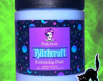 Könnte beinhalten: Ein hellblaues Glas "Bitchcraft Embalming Fluid" Körperlotion mit schwarzem Deckel. Das Etikett ist lila und zeigt ein Frauenporträt und den Text "Posh Goth". Das Glas ist mit Monden, Sternen und Planeten verziert. Eine schwarze Katzen-Silhouette ist im Bild.