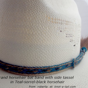 May include: A white cowboy hat with a teal, brown, and black horsehair hat band and a side tassel. The hat band is a 3 strand braid. The text on the image reads: "3 strand horsehair bat band with side tassel in Teal-sorrel-black horsehair from roberta at knot-a-tail.com"