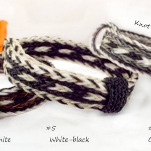 Puede incluir: Tres pulseras trenzadas de crin de caballo en marr&oacute;n, blanco y gris con detalles negros. Las pulseras est&aacute;n anudadas en los extremos.