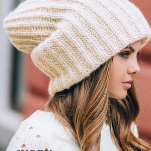 Puede incluir: Boina de punto de marfil con un ajuste holgado. La boina está hecha de un hilo suave y cálido y tiene una textura acanalada.