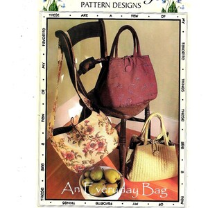 Puede incluir: Tres bolsos de tela diferentes, uno rojo, uno floral y uno amarillo, se muestran en una silla de madera. Los bolsos son de diferentes estilos y tamaños. La imagen es de un libro de patrones de costura e incluye el texto "Favorite Things Pattern Designs" y "An Everyday Bag".