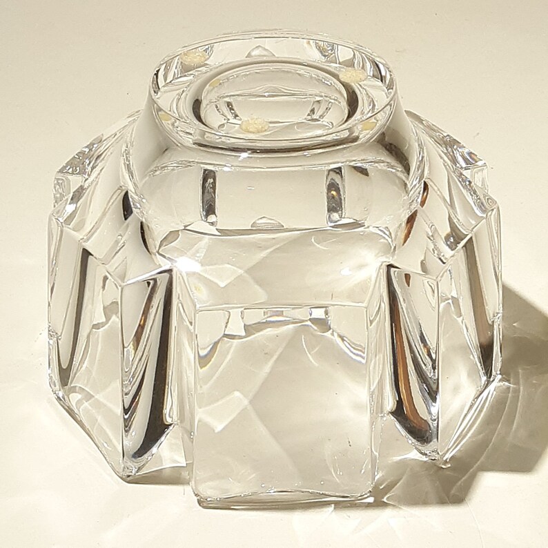 May include: A clear glass bowl with a faceted design. The bowl has a round base and a wide, open top.