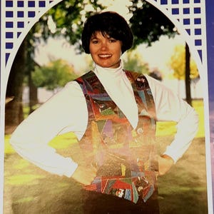 Puede incluir: Un chaleco sin mangas que presenta un diseño de patchwork multicolor con varios patrones geométricos en tonos rojo, azul, verde y amarillo, usado sobre una camisa blanca de cuello alto y manga larga con puños ajustados.