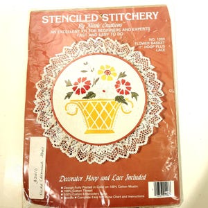 May include: Stenciled stitchery kit for a flower basket with a 7-inch hoop and lace. The kit includes 100% cotton muslin, thread, embroidery floss, a needle, and instructions.