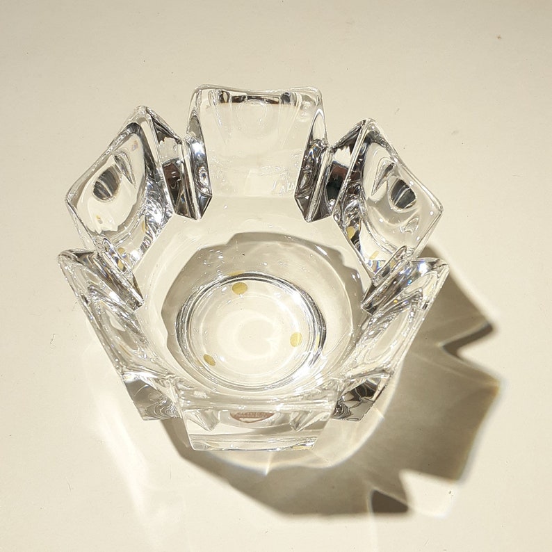 May include: A clear glass bowl with a starburst design. The bowl has a smooth, rounded bottom and a slightly flared rim.