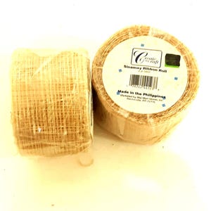 May include: Two rolls of beige sinamay ribbon. The label reads "Create Craft Sinamay Ribbon Roll" and "Made in the Philippines".