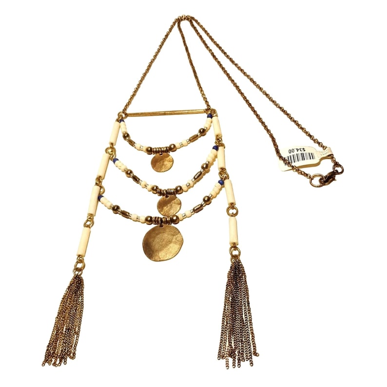 May include: A gold necklace with three tiers of white beads, gold discs, and small blue beads. The necklace has two gold tassels at the bottom and a gold chain with a clasp.