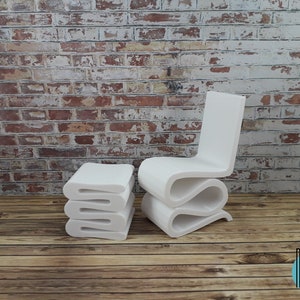 Puede incluir: Conjunto de silla y taburete modernos blancos. La silla y el taburete est&aacute;n hechos de un material blanco liso y tienen un dise&ntilde;o &uacute;nico y fluido. La silla tiene un respaldo y un asiento curvos, mientras que el taburete es una pila de tres piezas curvas.