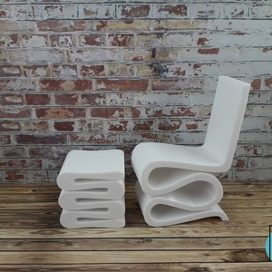 Puede incluir: Conjunto de silla y taburete modernos blancos. La silla tiene un dise&ntilde;o ondulado &uacute;nico y el taburete est&aacute; hecho de piezas planas apiladas. Ambas piezas est&aacute;n hechas de un material blanco liso.