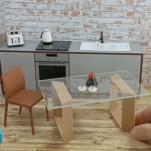 Pode incluir: Um conjunto de cozinha em miniatura com uma torradeira branca, uma chaleira branca, uma mesa de vidro com duas cadeiras marrons, um fogão preto e uma pia branca. O conjunto é feito de madeira e plástico.
