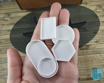 May include: Four white trays of different shapes and sizes. The trays are made of a smooth, white material and are perfect for organizing small items.