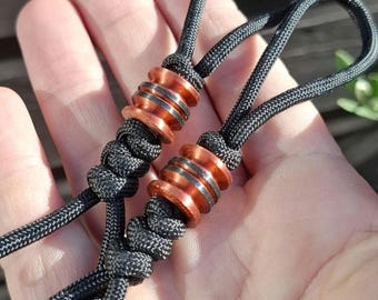 2 lanyard beads in copper color with black lines & grooves | Set of 2 shiny knifebeads with black 550 paracord lanyards. 1/4" / 6.4mm hole