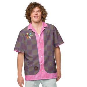 May include: A short-sleeved shirt with a pink collar and trim, featuring a checkerboard pattern in shades of purple and brown. A flower design is on the left chest. The shirt is paired with light blue shorts and white sneakers.