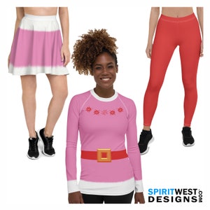 May include: A woman wearing a pink long-sleeve shirt with a red belt and gold buckle, paired with a pink skirt and red leggings. The shirt has a white collar and cuffs, and a snowflake design. Black sneakers complete the outfits.