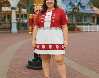 Puede incluir: Un vestido rojo y blanco con un diseño que recuerda a un uniforme de soldado de juguete. El vestido tiene mangas cortas, un frente decorativo y un borde inferior con patrones de remolino. La persona lleva zapatillas rojas.